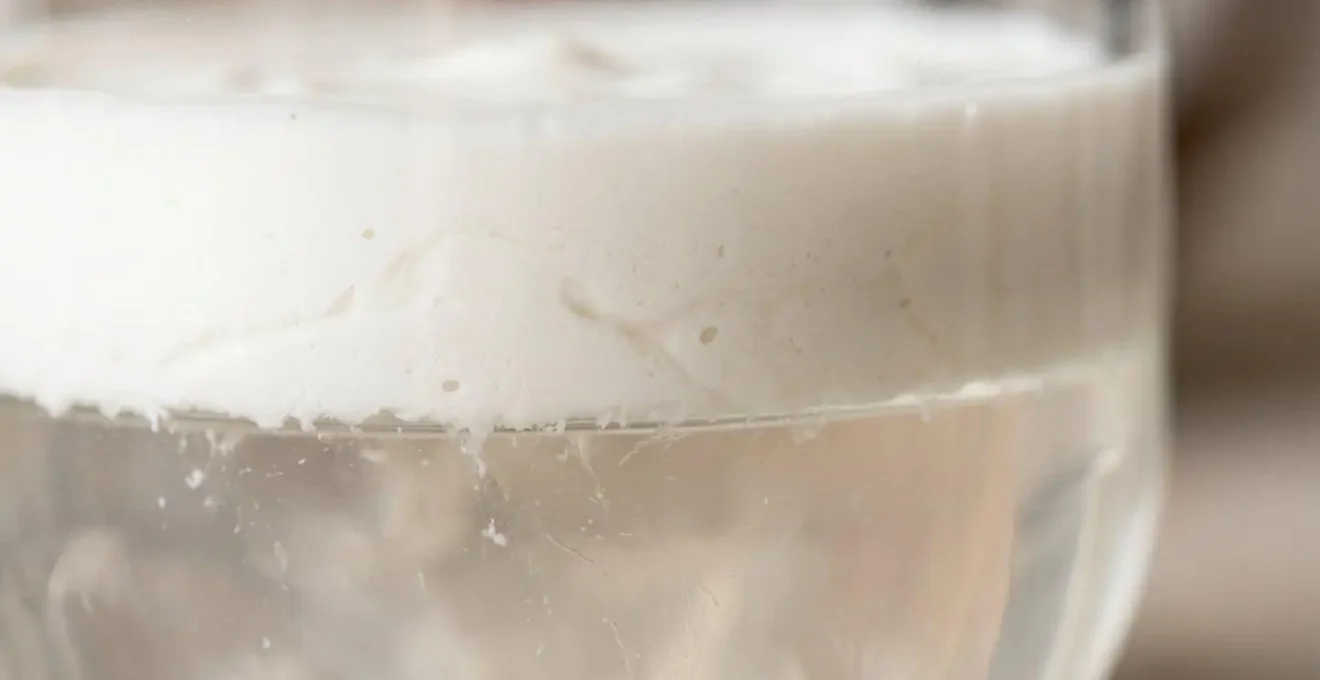 Gros plan macro sur la texture crémeuse du lait de coco révélant ses propriétés naturelles